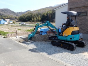 レンガ･天然石･アルミ枕木で仕上げた門柱と人工芝のラインを使ったガレージでシンプル&ナチュラルなイメージに。 掃出し窓の前は大きなウッドデッキとサンルームを設けています。